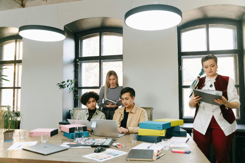 Startup founder and team planning content strategy on a laptop in a modern workspace.