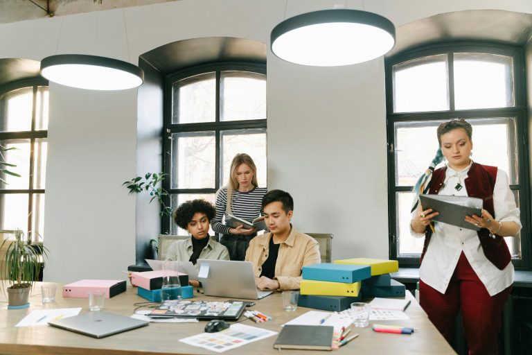 Startup founder and team planning content strategy on a laptop in a modern workspace.